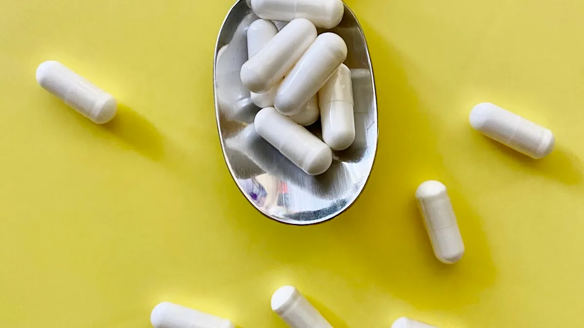 A white medication capsule resting beside a dark bottle.
