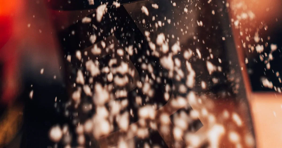 Protein powder falling from a scoop into a shaker bottle